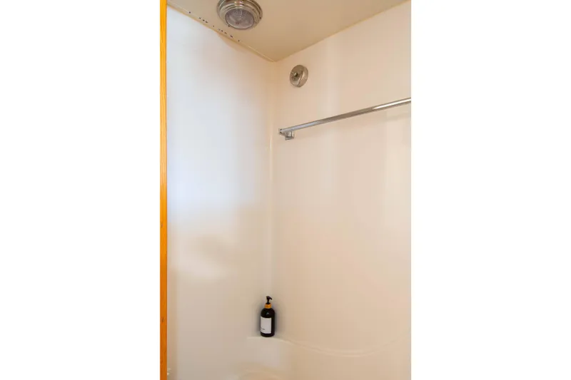 Slide: The Image of 1989 Chris-Craft Catalina boat shower interior with bottle and towel rack. - 11