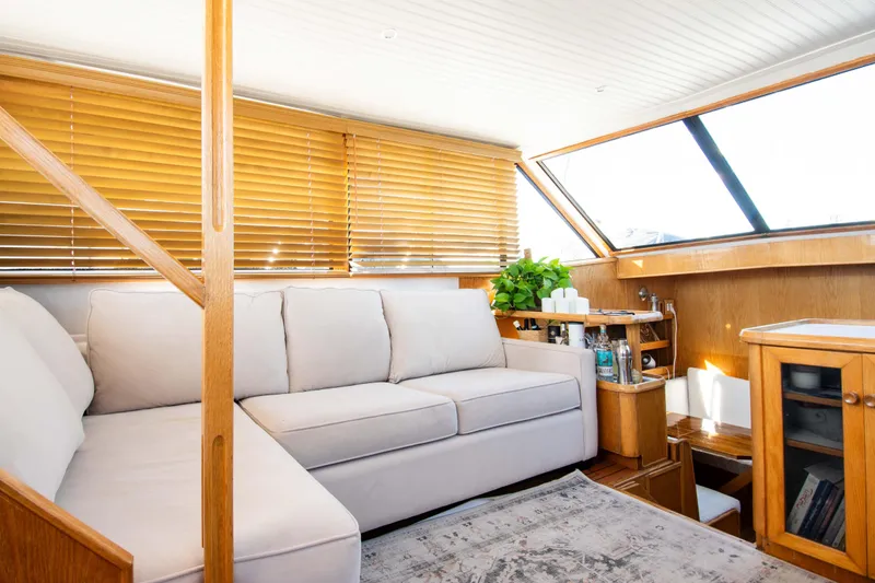 Slide: The Image of Interior of 1989 Chris-Craft Catalina yacht with cozy seating and wooden accents. - 13