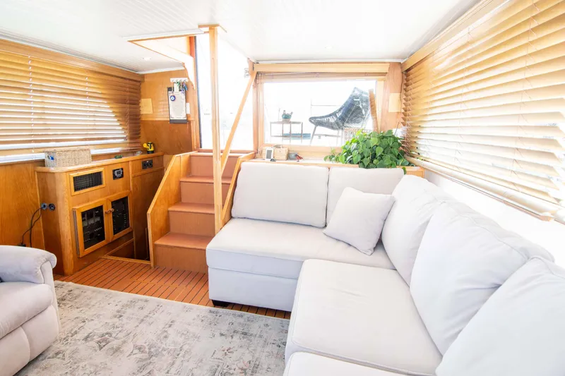 Slide: The Image of Interior of 1989 Chris-Craft Catalina boat with cozy seating and wooden accents. - 16