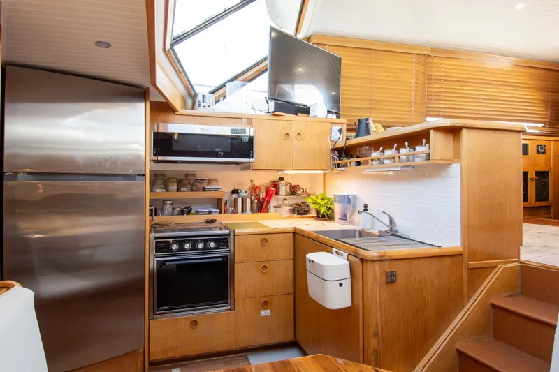Slide: The Image of 1989 Chris-Craft Catalina boat kitchen with wooden cabinetry, modern appliances, and skylight. - 19