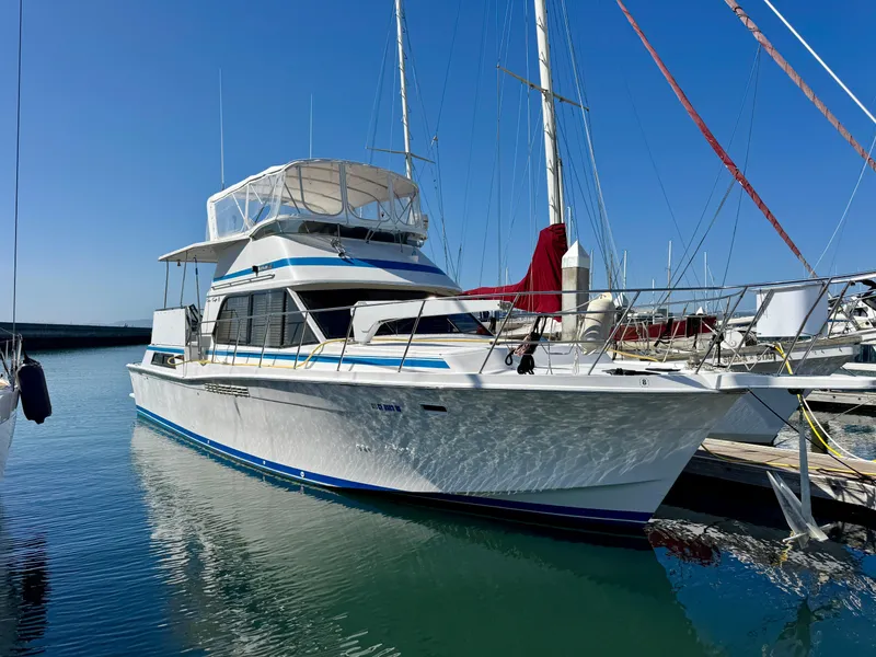 Slide: The Image of 1989 Chris-Craft Catalina boat docked in marina, clear blue sky, calm water. - 2