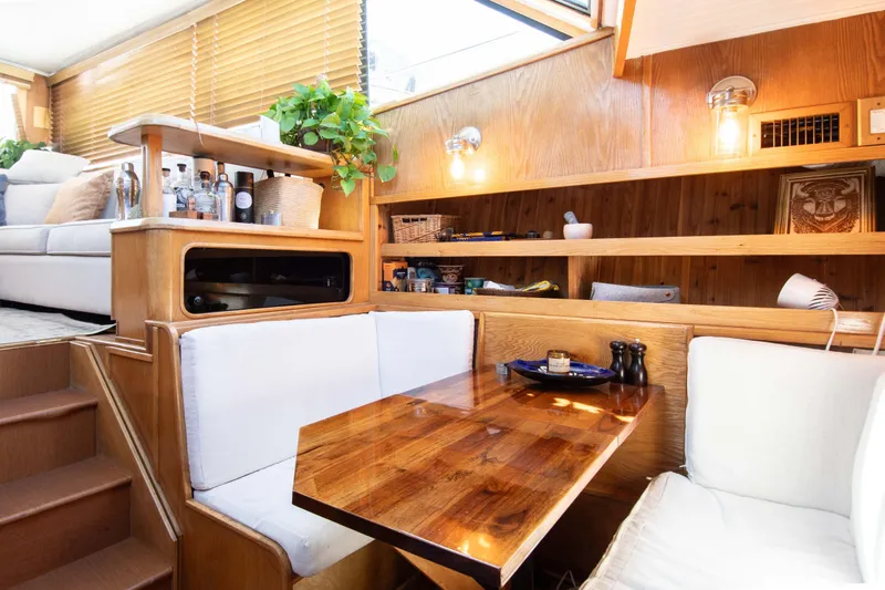 Slide: The Image of 1989 Chris-Craft Catalina interior with wooden dining area, cozy seating, and decorative shelves. - 20