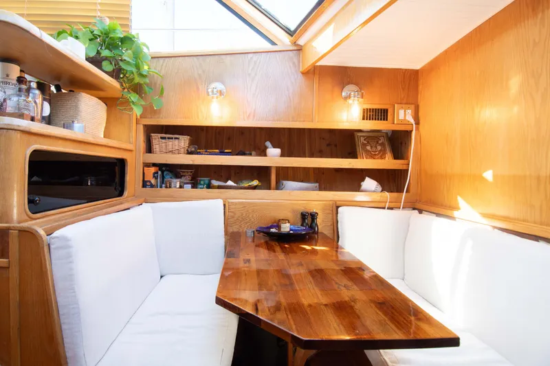 Slide: The Image of Cozy interior of 1989 Chris-Craft Catalina with wooden table and white seating. - 21