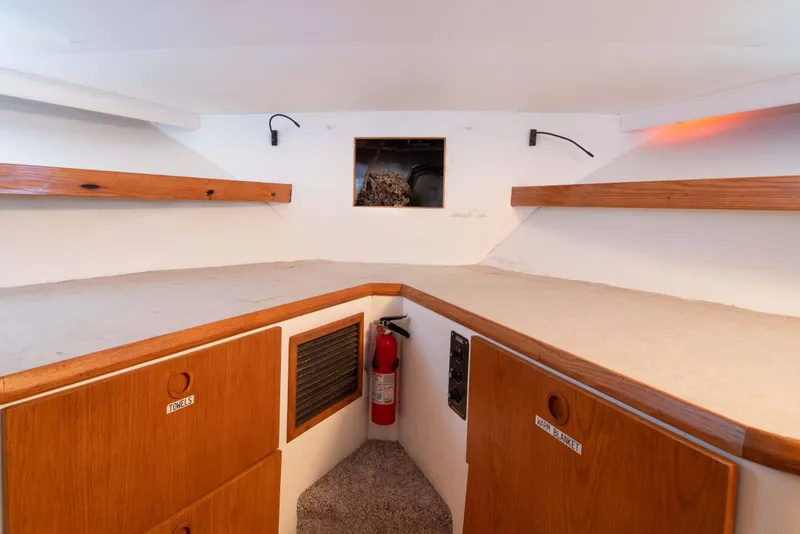 Slide: The Image of 1989 Chris-Craft Catalina cabin interior with wooden shelves and storage compartments. - 23