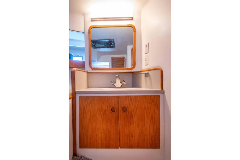 Slide: The Image of 1989 Chris-Craft Catalina bathroom with wooden vanity, mirror, and modern fixtures. - 24