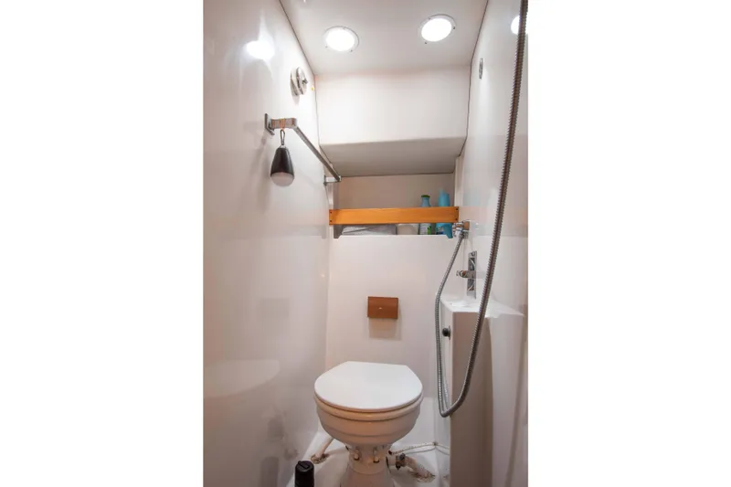 Slide: The Image of 1989 Chris-Craft Catalina boat bathroom with toilet, shower, and storage shelf. - 25