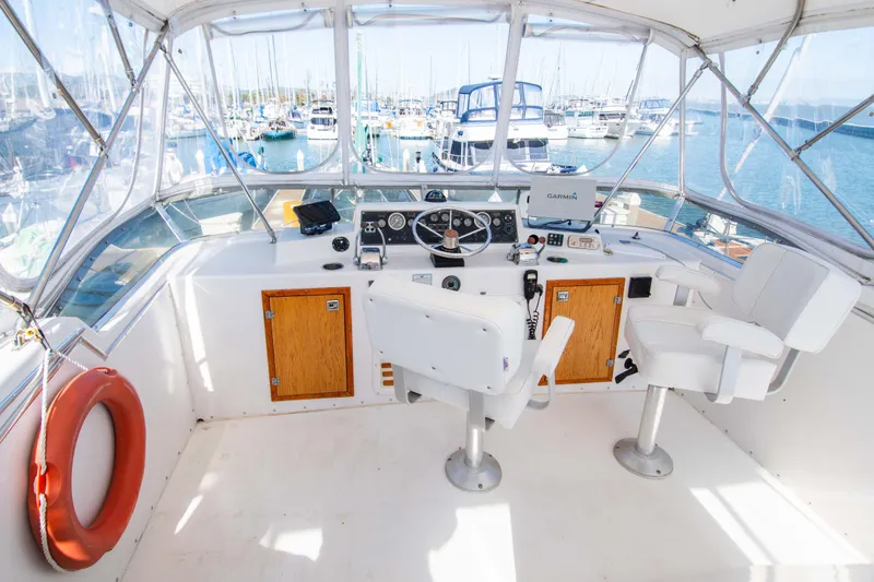 Slide: The Image of 1989 Chris-Craft Catalina boat helm with marina view, featuring navigation equipment and seating. - 3