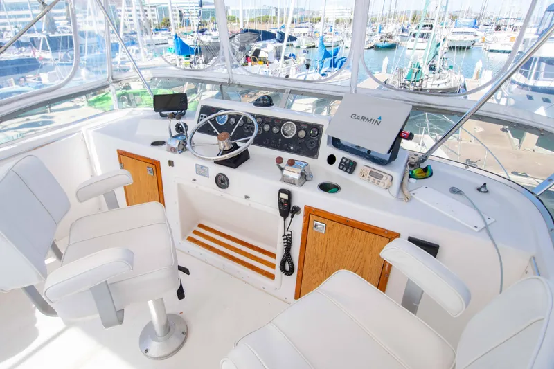 Slide: The Image of 1989 Chris-Craft Catalina boat cockpit with steering wheel, Garmin navigation, and marina view. - 4