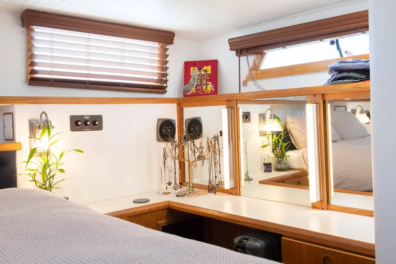 Slide: The Image of Cozy 1989 Chris-Craft Catalina cabin interior with mirrors, plants, and wooden accents. - 9