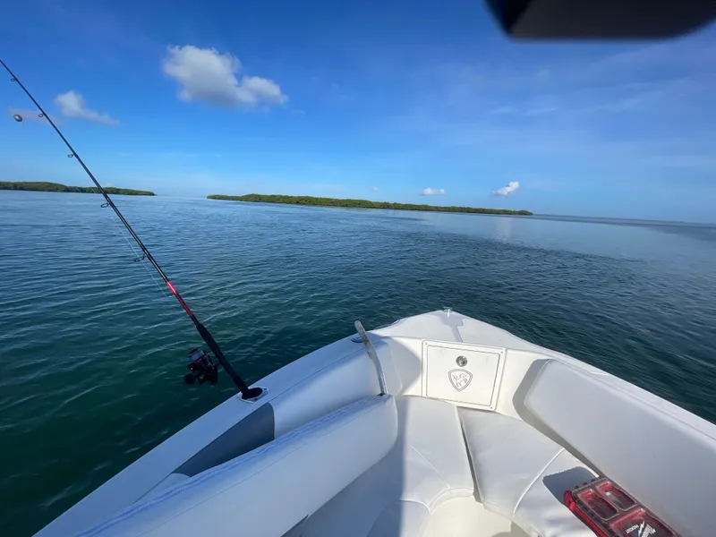 Slide: The Image of Century 2600 Center Console boat on calm water, fishing rod visible, clear blue sky. - 12