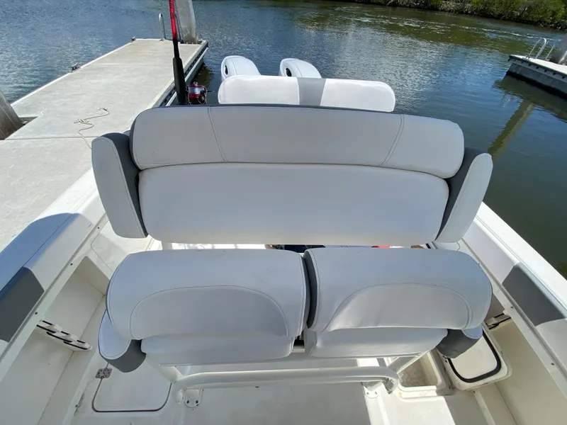 Slide: The Image of 2017 Century 2600 Center Console boat with white seating, docked by the water. - 15