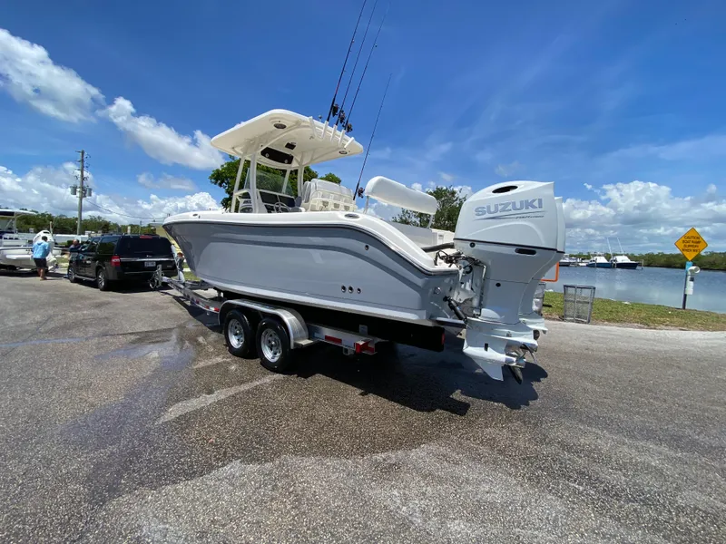 Slide: The Image of 2017 Century 2600 Center Console boat on trailer with Suzuki engine, near waterfront. - 18