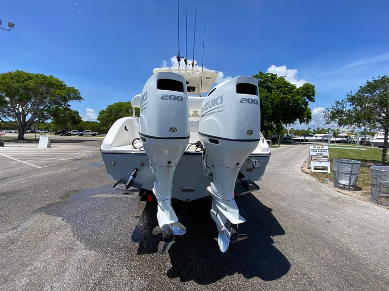 Slide: The Image of 2017 Century 2600 Center Console boat with twin Suzuki 200 engines in a parking lot. - 19