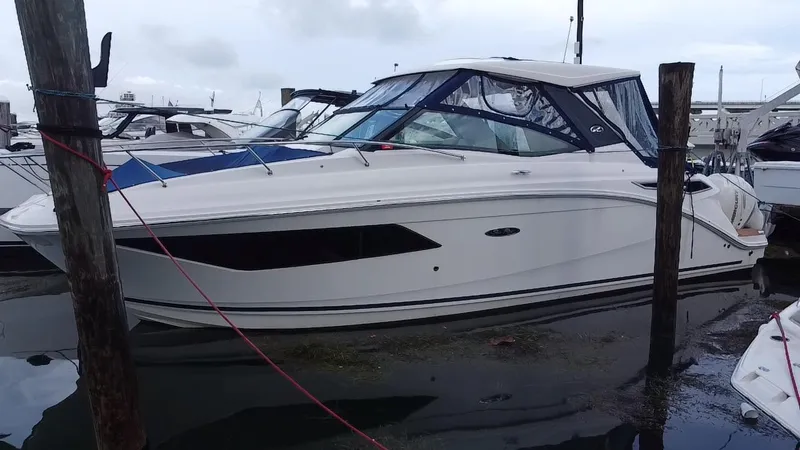 Slide: The Image of 2020 Sea Ray Sundancer 320 OB boat docked at marina, side view. - 2