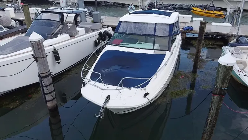 Slide: The Image of 2020 Sea Ray Sundancer 320 OB docked at marina, covered with blue tarp. - 4
