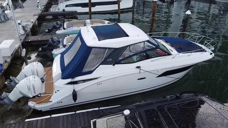 Slide: The Image of 2020 Sea Ray Sundancer 320 OB docked at marina with blue canopy. - 6