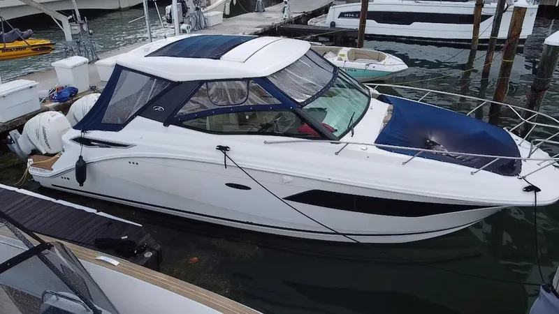 Slide: The Image of 2020 Sea Ray Sundancer 320 OB docked at marina, featuring sleek design and outboard engines. - 7