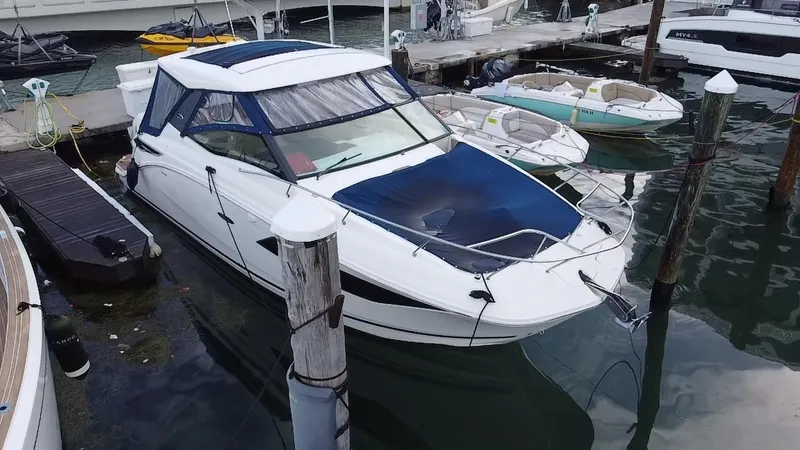 Slide: The Image of 2020 Sea Ray Sundancer 320 OB docked at marina, featuring sleek design and blue canopy. - 8