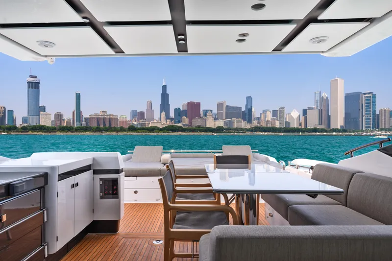 Slide: The Image of Luxurious 2019 Azimut S7 yacht with city skyline view, featuring elegant outdoor seating and dining area. - 15