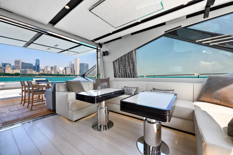 Slide: The Image of Luxurious 2019 Azimut S7 yacht interior with city skyline view, featuring elegant seating and dining area. - 26