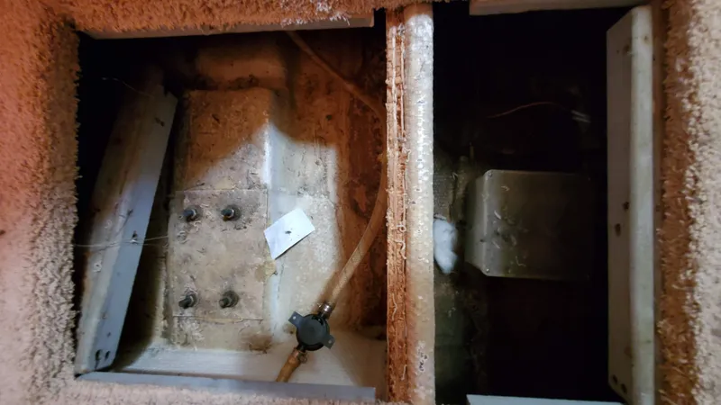 Slide: The Image of 1985 Silverton 40 Aft Cabin interior compartment, showing wiring and structural components. - 10