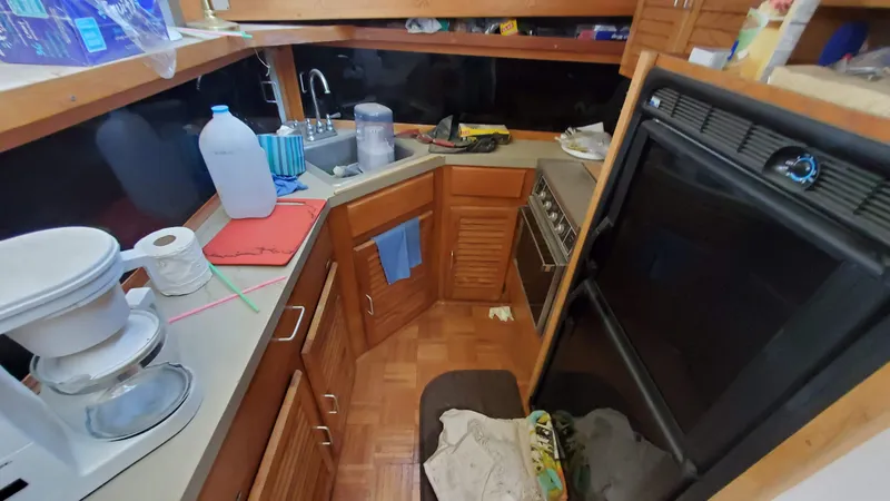 Slide: The Image of 1985 Silverton 40 Aft Cabin kitchen with wooden cabinets and appliances. - 14