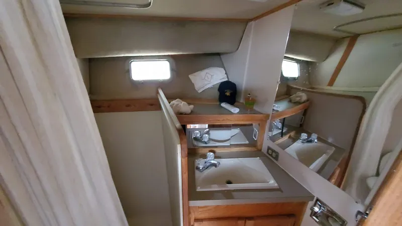 Slide: The Image of 1985 Silverton 40 Aft Cabin bathroom with dual sinks and mirrors. - 15