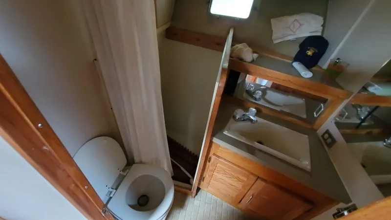 Slide: The Image of 1985 Silverton 40 Aft Cabin bathroom with sink, toilet, and mirror. - 16