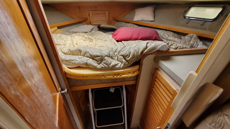 Slide: The Image of 1985 Silverton 40 Aft Cabin interior with cozy bed and wooden accents. - 17