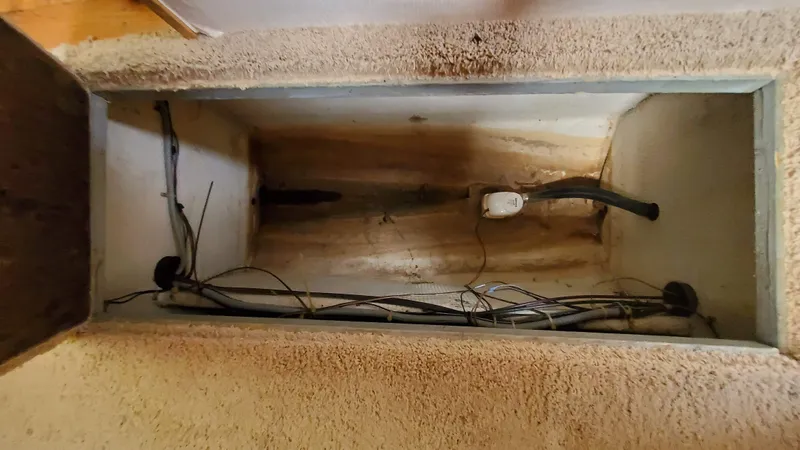 Slide: The Image of 1985 Silverton 40 Aft Cabin interior compartment with visible wiring and plumbing. - 18