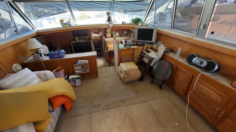 Slide: The Image of 1985 Silverton 40 Aft Cabin interior with cozy seating, wooden cabinetry, and electronics. - 19