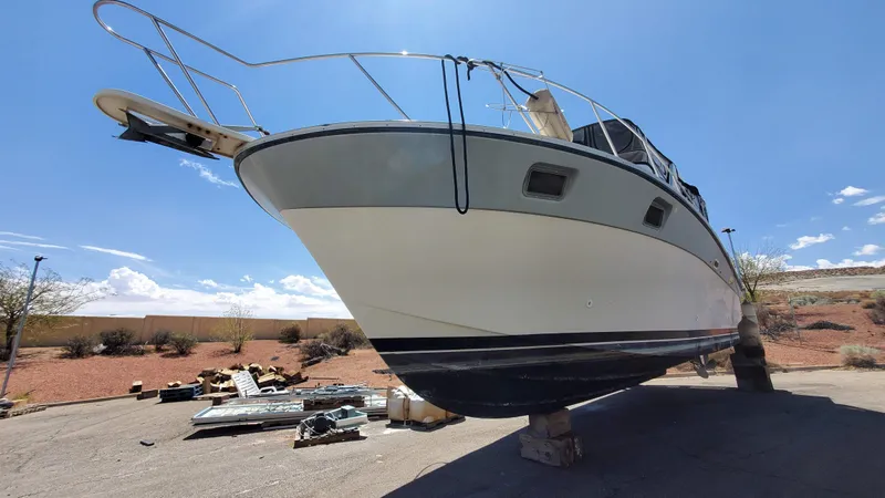 Slide: The Image of 1985 Silverton 40 Aft Cabin boat on dry land under clear blue sky. - 2