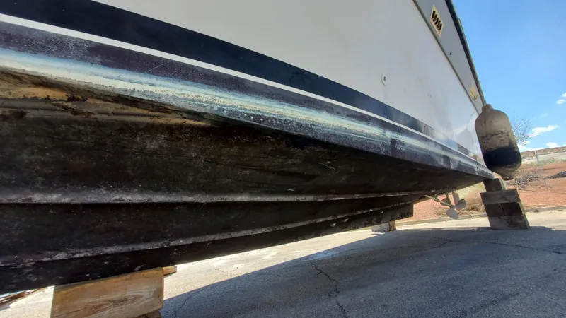 Slide: The Image of 1985 Silverton 40 Aft Cabin boat hull on dry dock, showing underside and support blocks. - 26
