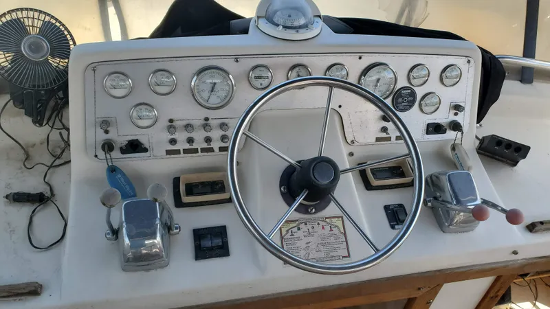 Slide: The Image of 1985 Silverton 40 Aft Cabin helm with gauges, steering wheel, and controls. - 3