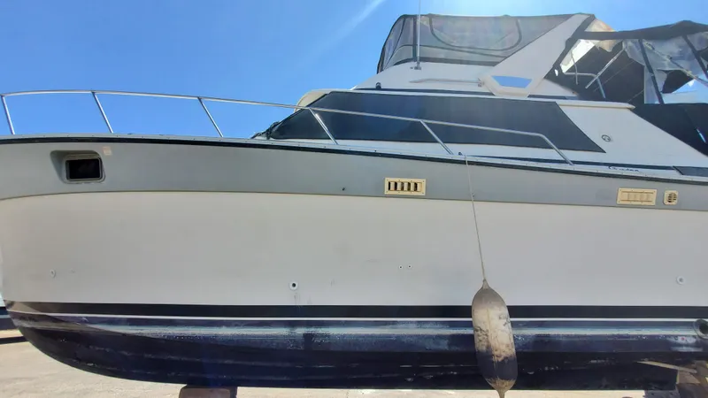 Slide: The Image of 1985 Silverton 40 Aft Cabin boat with blue and white exterior, docked under clear sky. - 30