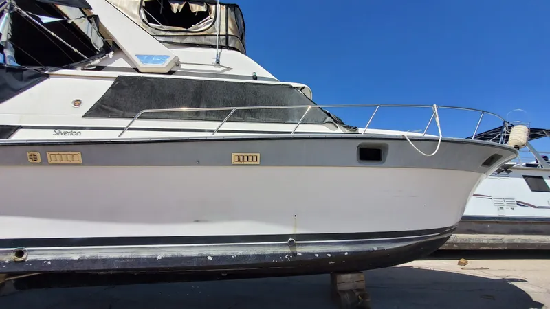 Slide: The Image of 1985 Silverton 40 Aft Cabin boat on dry dock, side view under clear blue sky. - 36