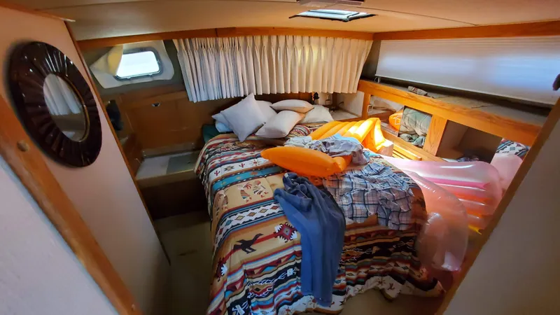 Slide: The Image of 1985 Silverton 40 Aft Cabin bedroom with colorful bedding and natural light. - 4