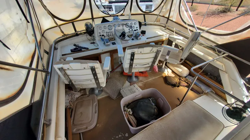 Slide: The Image of 1985 Silverton 40 Aft Cabin helm with vintage controls and seating, enclosed by canvas. - 41