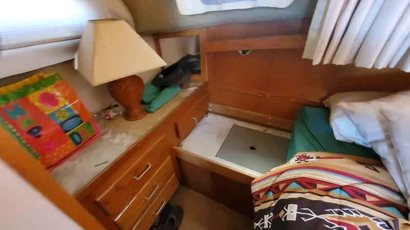 Slide: The Image of 1985 Silverton 40 Aft Cabin interior with bed, lamp, and colorful decor. - 5