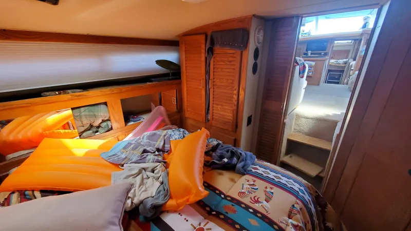 Slide: The Image of 1985 Silverton 40 Aft Cabin interior with colorful bedding and inflatable mattress. - 7