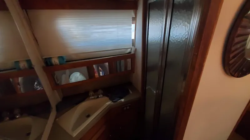 Slide: The Image of 1985 Silverton 40 Aft Cabin bathroom with sink, mirror, and shower. - 9