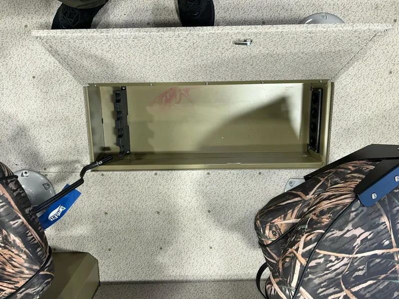 Slide: The Image of 2023 Crestliner 1650 Discovery Tiller storage compartment with camo seats and textured flooring. - 10