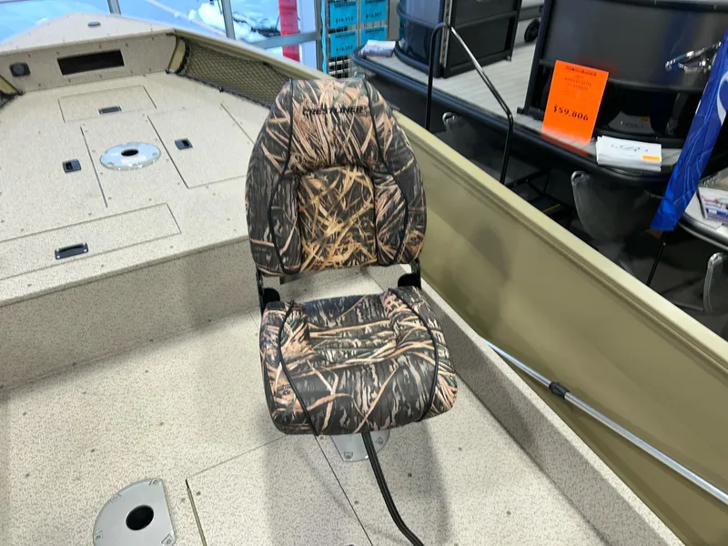 Slide: The Image of Crestliner 1650 Discovery Tiller 2023 boat with camo-patterned seat in showroom. - 11