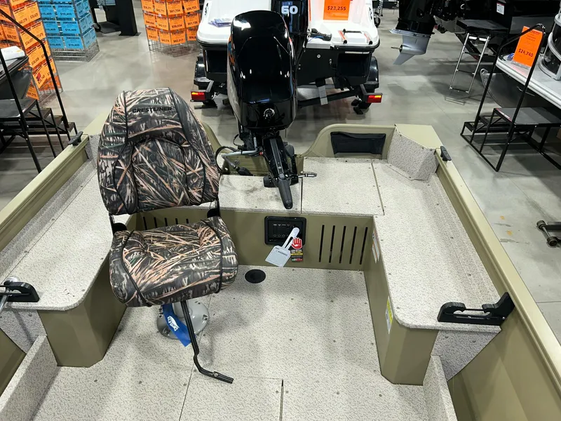 Slide: The Image of 2023 Crestliner 1650 Discovery Tiller boat interior with camo seat and motor. - 7