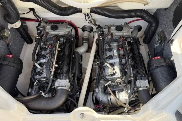 Slide: The Image of 2015 Yamaha SX210 boat engine compartment with dual engines and hoses. - 15