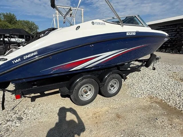 Slide: The Image of 2015 Yamaha SX210 boat on trailer, blue and white design, twin engine, outdoor setting. - 3