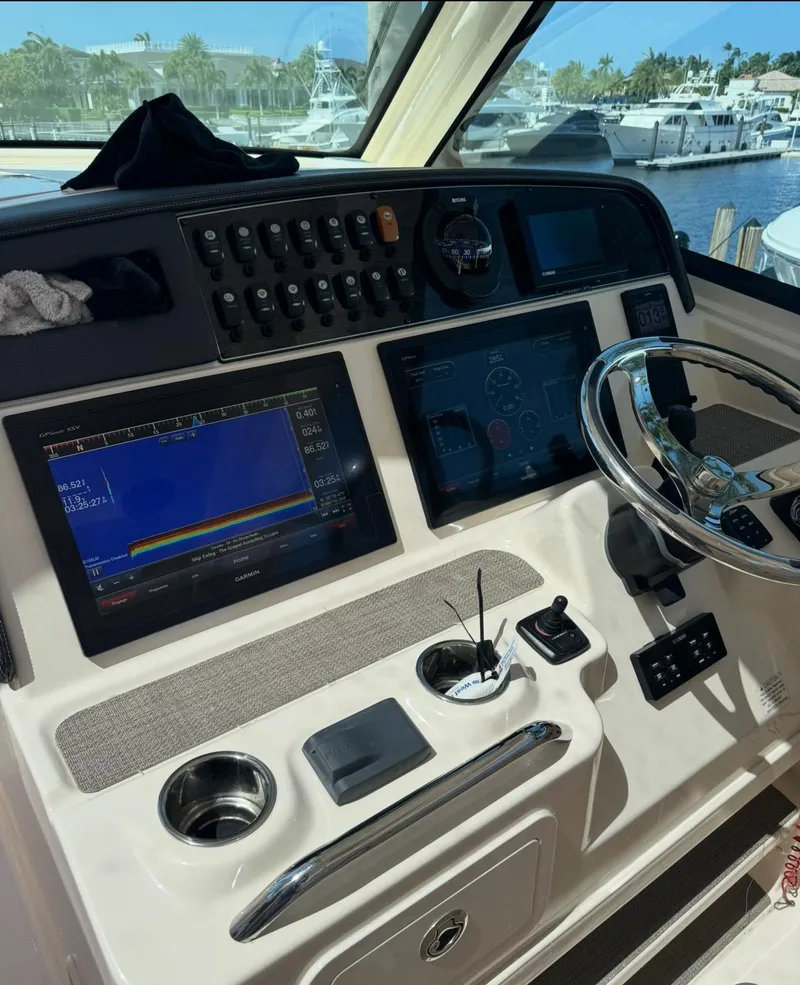 Slide: The Image of 2019 Grady-White Freedom 375 boat dashboard with navigation screens and steering wheel. - 11