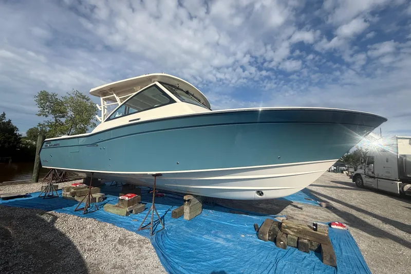 Slide: The Image of 2019 Grady-White Freedom 375 boat on stands, blue hull, sunny day. - 2