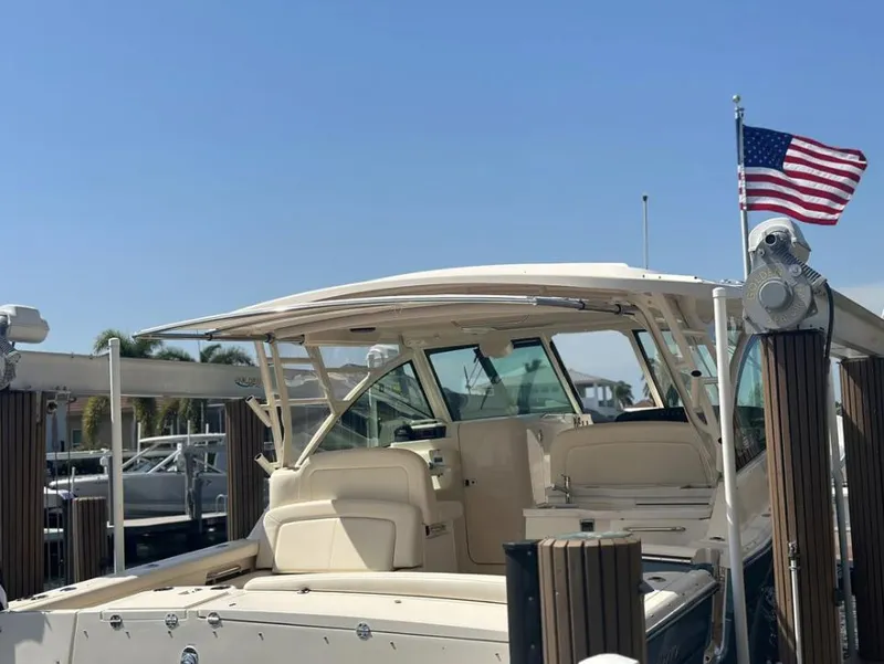 Slide: The Image of 2019 Grady-White Freedom 375 boat docked with American flag, clear sky background. - 20