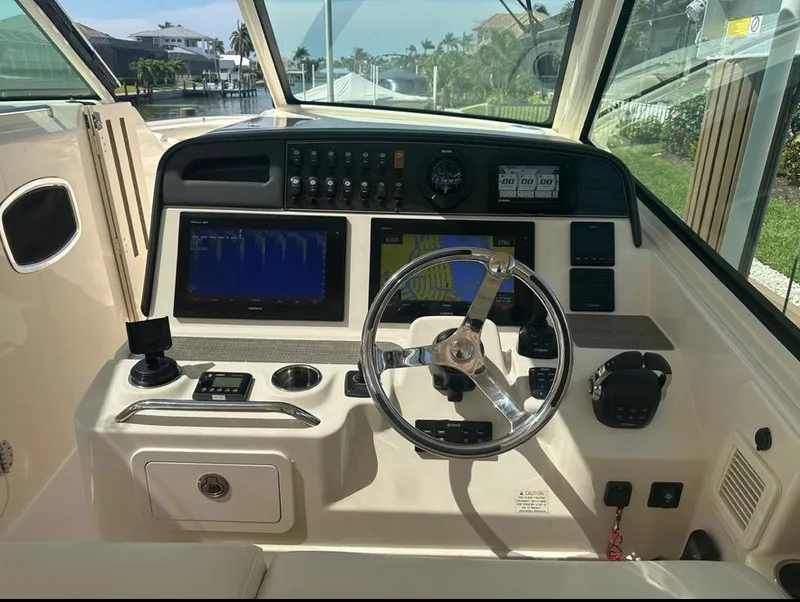Slide: The Image of 2019 Grady-White Freedom 375 boat dashboard with steering wheel and navigation controls. - 22